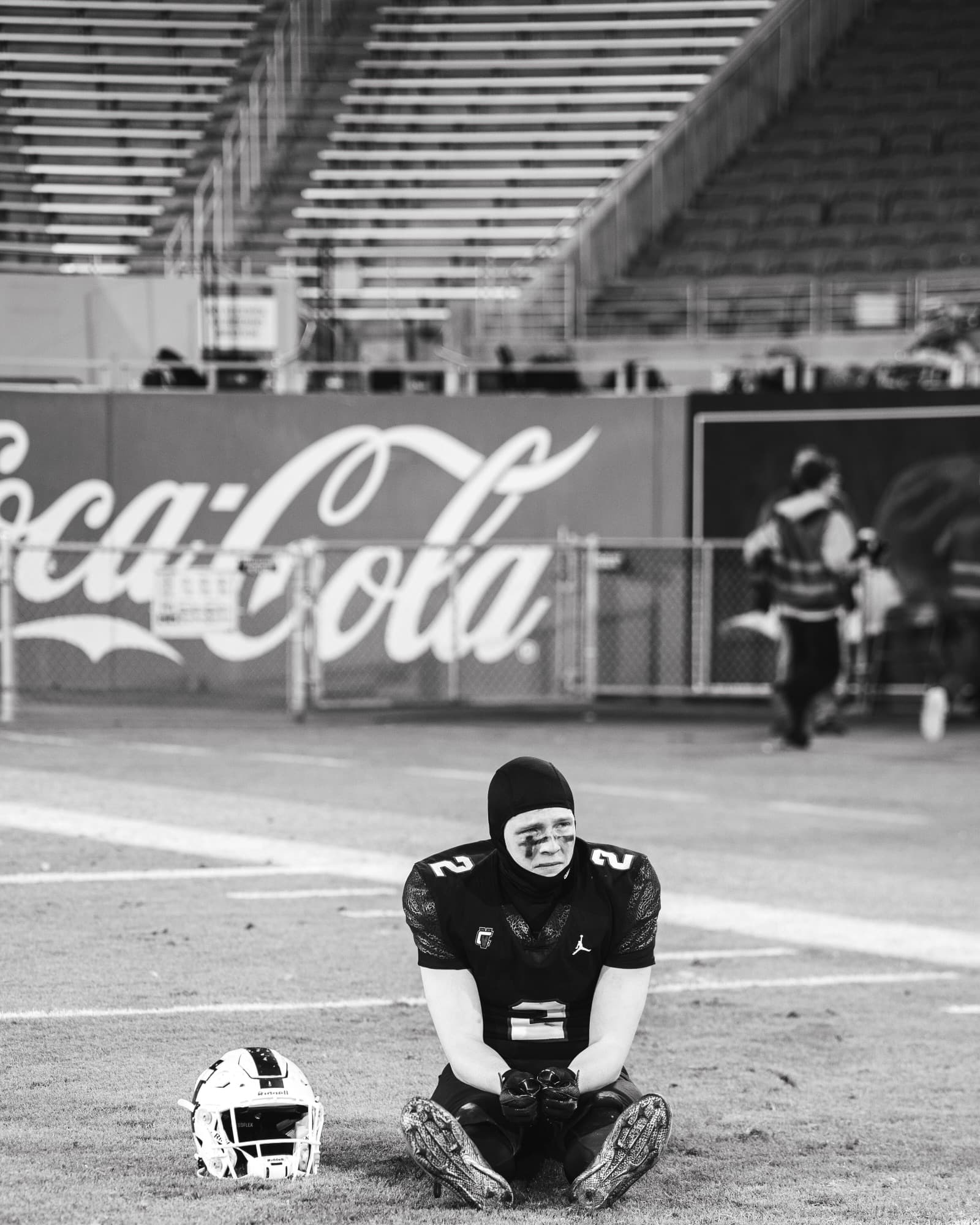 Player kneeling with helmet off after the 5A championship